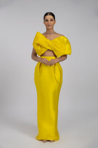 HerTrove-A long yellow taffeta evening dress with a modern design featuring a large bow and a transparent back.