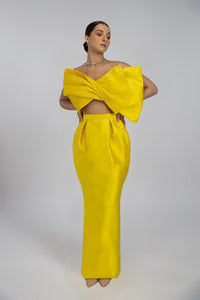 HerTrove-A long yellow taffeta evening dress with a modern design featuring a large bow and a transparent back.
